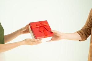 close-up do homem dando caixa de presente vermelha para mulher sobre fundo branco foto