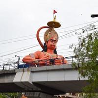 nova delhi, índia - 21 de junho de 2022 - grande estátua do senhor hanuman perto da ponte do metrô de delhi situada perto de karol bagh, delhi, índia, estátua do senhor hanuman tocando o céu foto