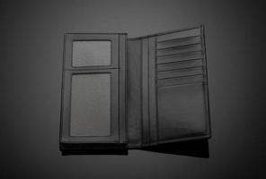 um close de uma carteira de couro elegante em um fundo escuro foto