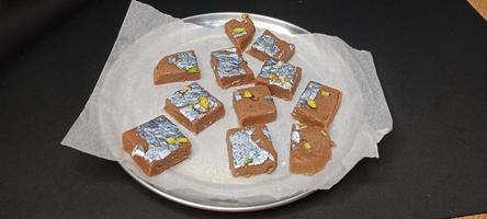 receita de biscoito doce, comida doce indiana feita de biscoito, biscoito mithai, leite barfi em fundo de madeira foto