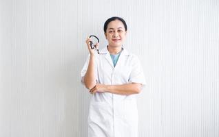 o médico de mulher confiante e sorridente fechado com uniforme branco e dispositivo médico em fundo branco no hospital ou clínica, médica asiática em vestido médico, negócios de saúde foto