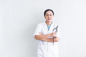 o médico de mulher confiante e sorridente fechado com uniforme branco e dispositivo médico em fundo branco no hospital ou clínica, médica asiática em vestido médico, negócios de saúde foto