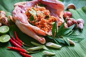 comida de cannabis para cozinhar com frango fresco folha de cannabis vegetais de maconha ervas e especiarias ingredientes no fundo da folha de bananeira, planta de folha de cânhamo de frango cru thc cbd ervas - comida tailandesa foto