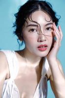modelo de mulher asiática de cabelo molhado atraente jovem com pele fresca perfeita na simulação subaquática de iluminação cuidados faciais tratamento facial cosmetologia cirurgia plástica retrato de menina adorável em estúdio foto