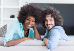 jovem casal multiétnico na sala de estar foto