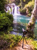 câmera dslr profissional em um tripé na bela cachoeira foto