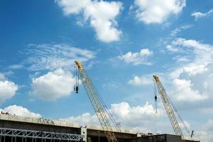 guindaste e construção civil e céu azul foto