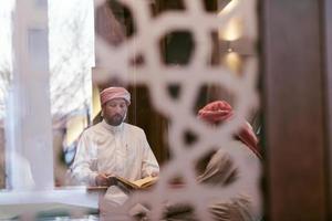 pessoas muçulmanas na mesquita lendo o Alcorão juntos foto