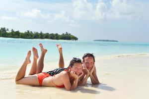 feliz casal jovem se divertir na praia foto