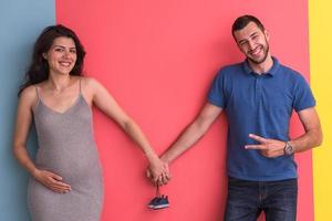 jovem casal feliz segurando sapatos de bebê recém-nascido foto