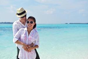 feliz casal jovem se divertir na praia foto