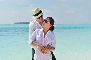 feliz casal jovem se divertir na praia foto