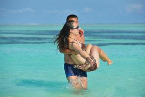 casal jovem feliz curtindo o verão na praia foto