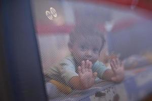 bebezinho brincando na cama móvel foto