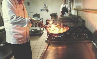 chef fazendo flambe na comida foto