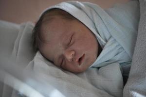 bebê recém-nascido dormindo na cama no hospital foto