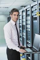 jovem engenheiro de TI na sala do servidor do datacenter foto