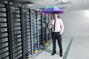 empresário segura guarda-chuva na sala do servidor foto