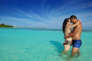 casal jovem feliz curtindo o verão na praia foto