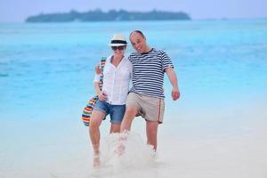 feliz casal jovem se divertir na praia foto