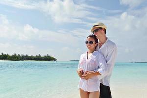 feliz casal jovem se divertir na praia foto