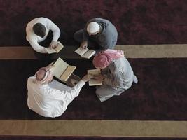 vista superior do povo muçulmano na mesquita lendo o Alcorão juntos foto