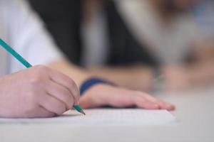 estudante do sexo masculino tomando notas em sala de aula foto