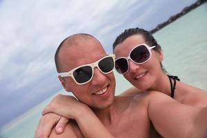 casal jovem feliz nas férias de verão se divertir e relaxar na praia foto