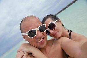 feliz casal jovem se divertir na praia foto