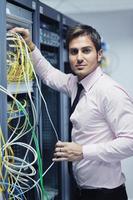 jovem engenheiro de TI na sala do servidor do datacenter foto