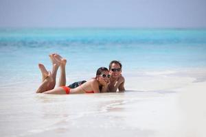 feliz casal jovem se divertir na praia foto