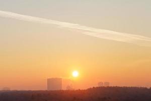 céu laranja do nascer do sol sobre a cidade no inverno frio foto