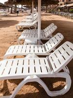 cadeiras vazias na praia na cidade de aqaba no inverno foto