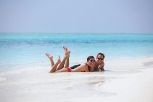 feliz casal jovem se divertir na praia foto