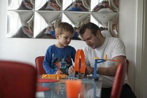 pai e filhos jogando jogo de brinquedo de carro foto