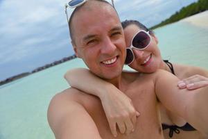 casal jovem feliz nas férias de verão se divertir e relaxar na praia foto