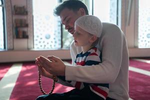oração muçulmana pai e filho na mesquita rezando juntos, conceito de educação islâmica foto