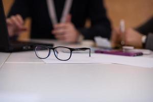 laptop e óculos na mesa de escritório foto