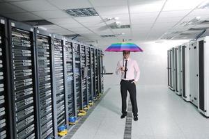 empresário segura guarda-chuva na sala do servidor foto