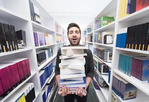 estudante segurando muitos livros na biblioteca da escola foto