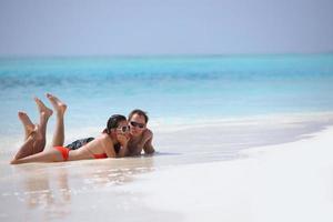 feliz casal jovem se divertir na praia foto