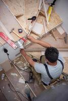 carpinteiro instalando escadas de madeira foto
