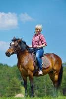 mulher feliz a cavalo foto