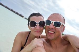 casal jovem feliz nas férias de verão se divertir e relaxar na praia foto