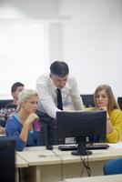 alunos com professor em sala de aula de laboratório de informática foto