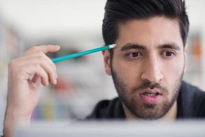 estudante na biblioteca da escola usando laptop para pesquisa foto