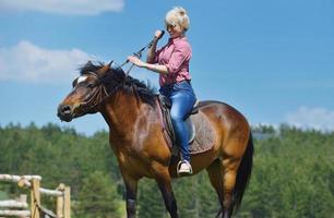 mulher feliz a cavalo foto