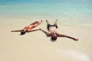 feliz casal jovem se divertir na praia foto