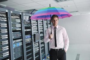 empresário segura guarda-chuva na sala do servidor foto