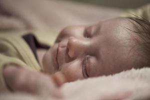 bebê recém-nascido dormindo em casa na cama foto